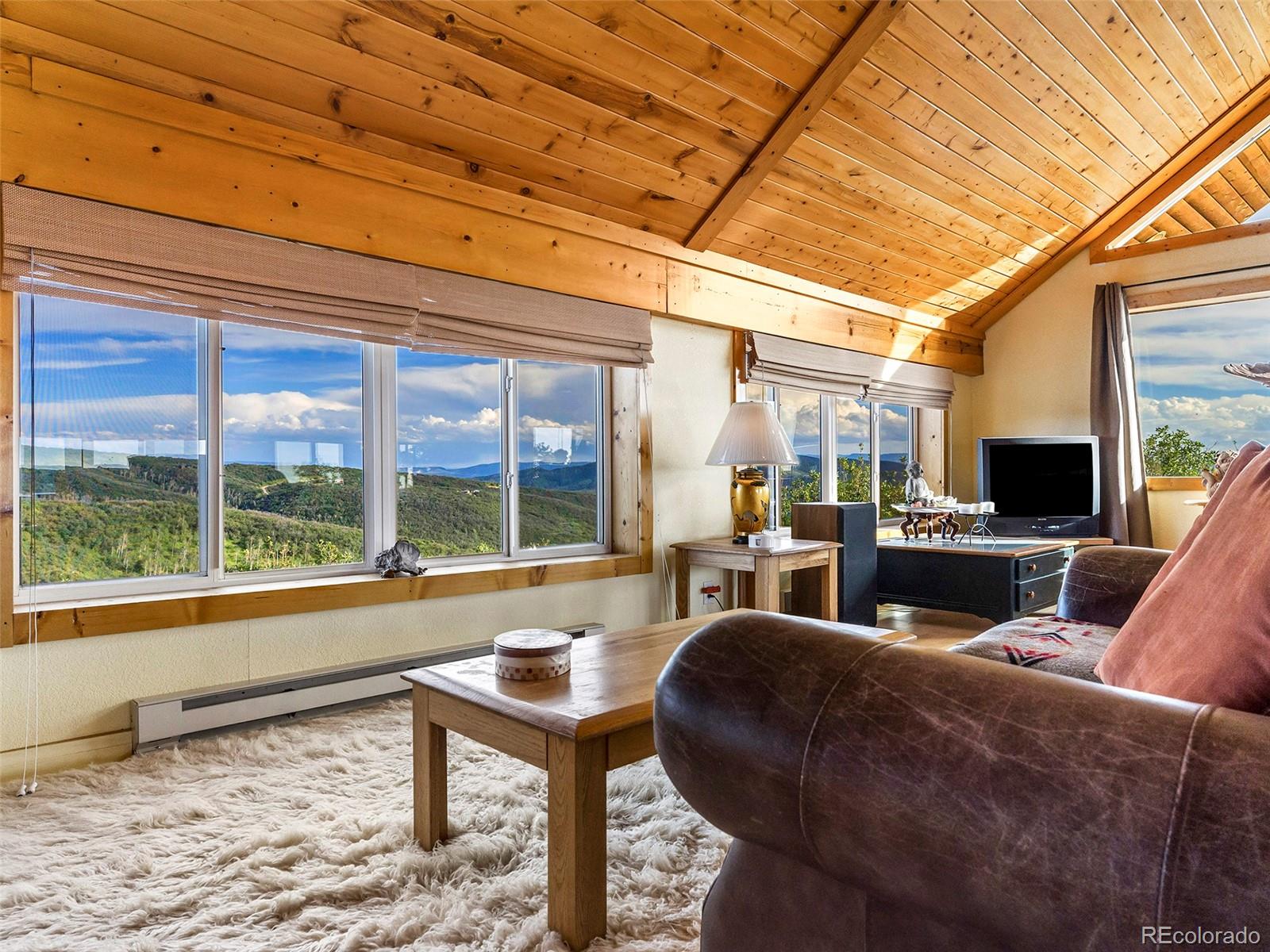 40705 Hill N Dale Road Steamboat Springs, CO 80487 - Photo 7 of 37 a living room with furniture and a floor to ceiling window