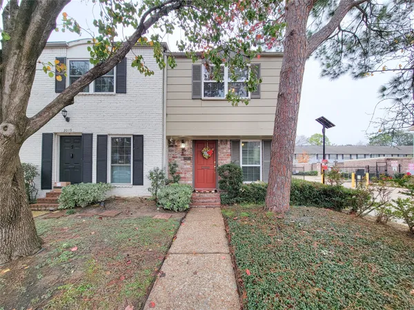 a front view of a house with garden and plants