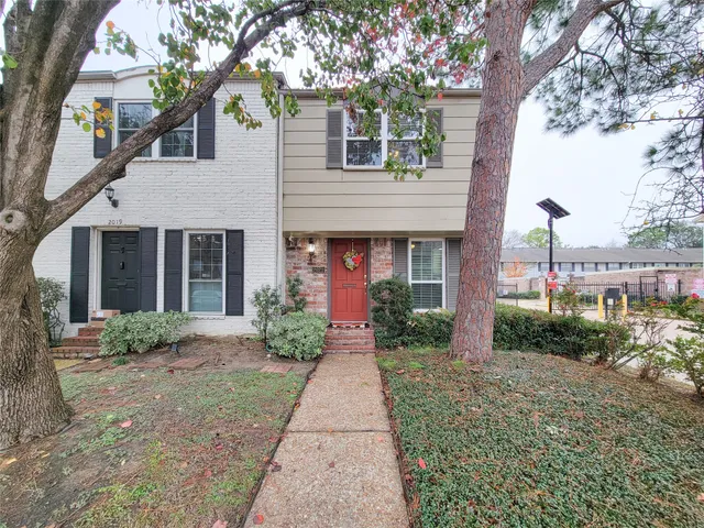 a front view of a house with garden and plants