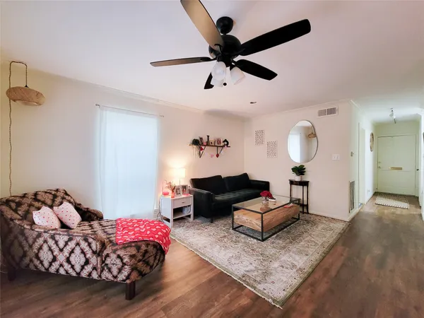 a living room with furniture and wooden floor