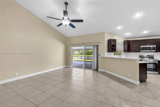 a kitchen with kitchen island granite countertop stainless steel appliances and refrigerator