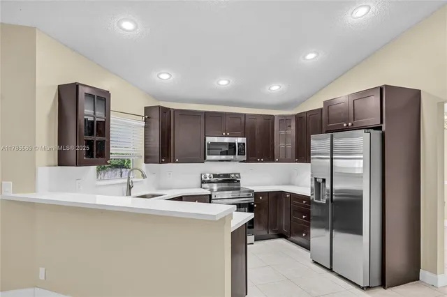 a kitchen with stainless steel appliances a sink stove and microwave