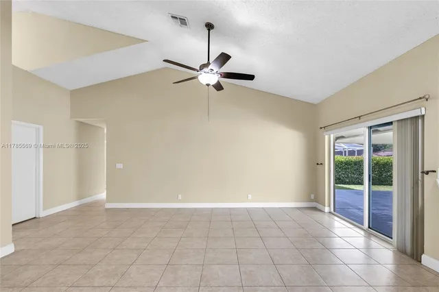 en empty room with windows and chandelier