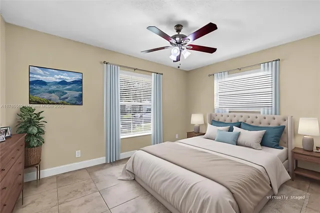 a view of an empty room with chandelier fan and fire place