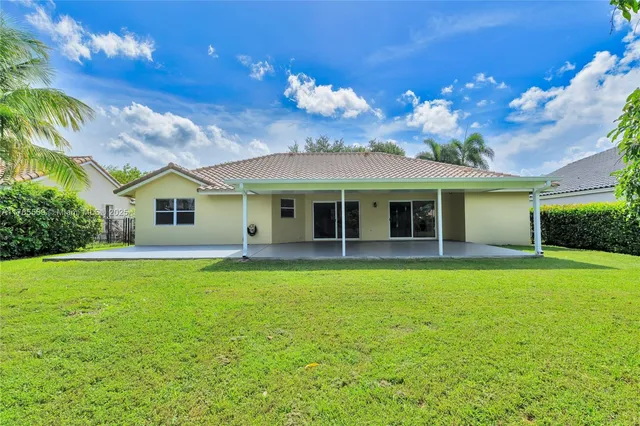 a view of a park with large trees and a flower garden