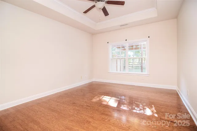 an empty room with windows and ceiling fan