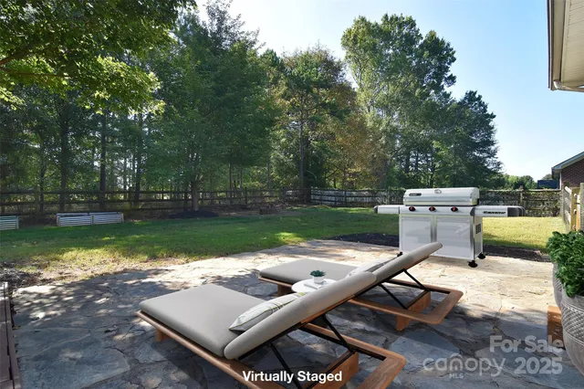 a backyard of a house with yard table and chairs