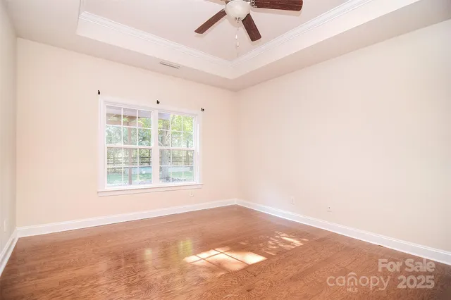 an empty room with a ceiling fan and window