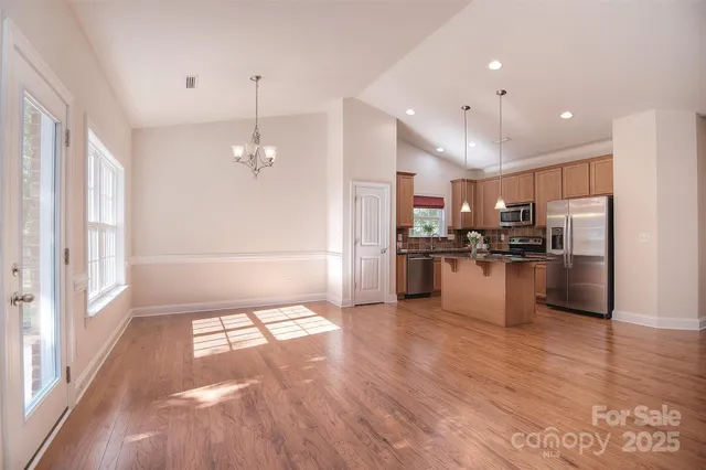 a view of kitchen with refrigerator stove and wooden floor