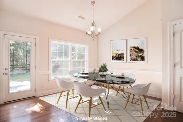 a dining room with furniture a chandelier and wooden floor