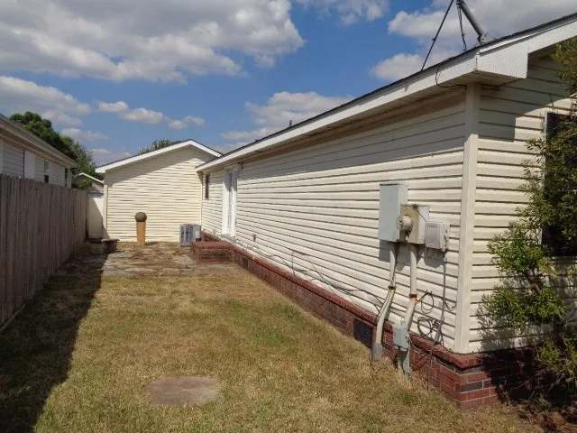 a view of a house with a yard and potted plants