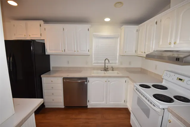 a kitchen with a sink a stove and cabinets