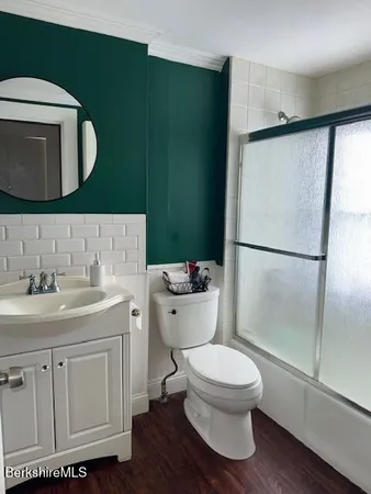 a bathroom with a toilet a sink and mirror