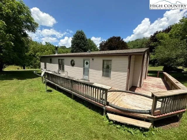 a view of backyard with deck and outdoor seating