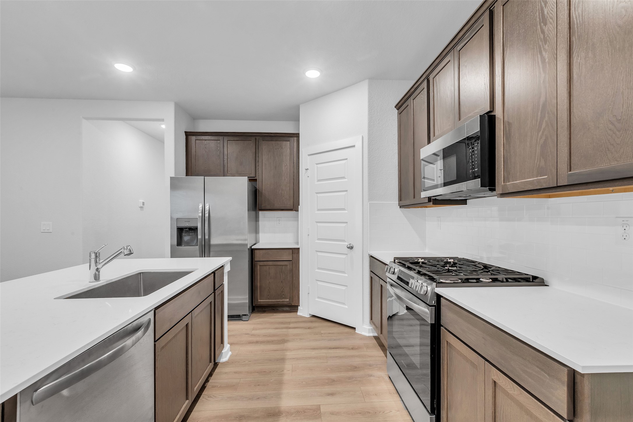 8550 Blueberry Ash Street Magnolia, TX 77354 - Photo 11 of 40 a kitchen with stainless steel appliances a sink stove and refrigerator
