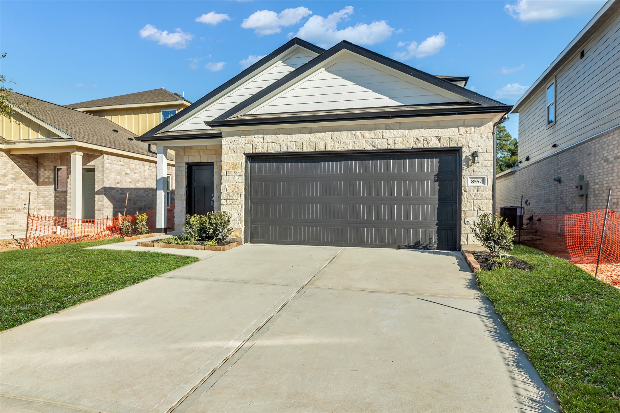 8550 Blueberry Ash Street Magnolia, TX 77354 - Photo 2 of 40 a front view of a house with a yard and garage