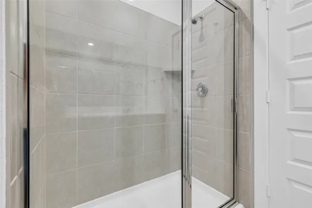 a bathroom with a shower and a glass door