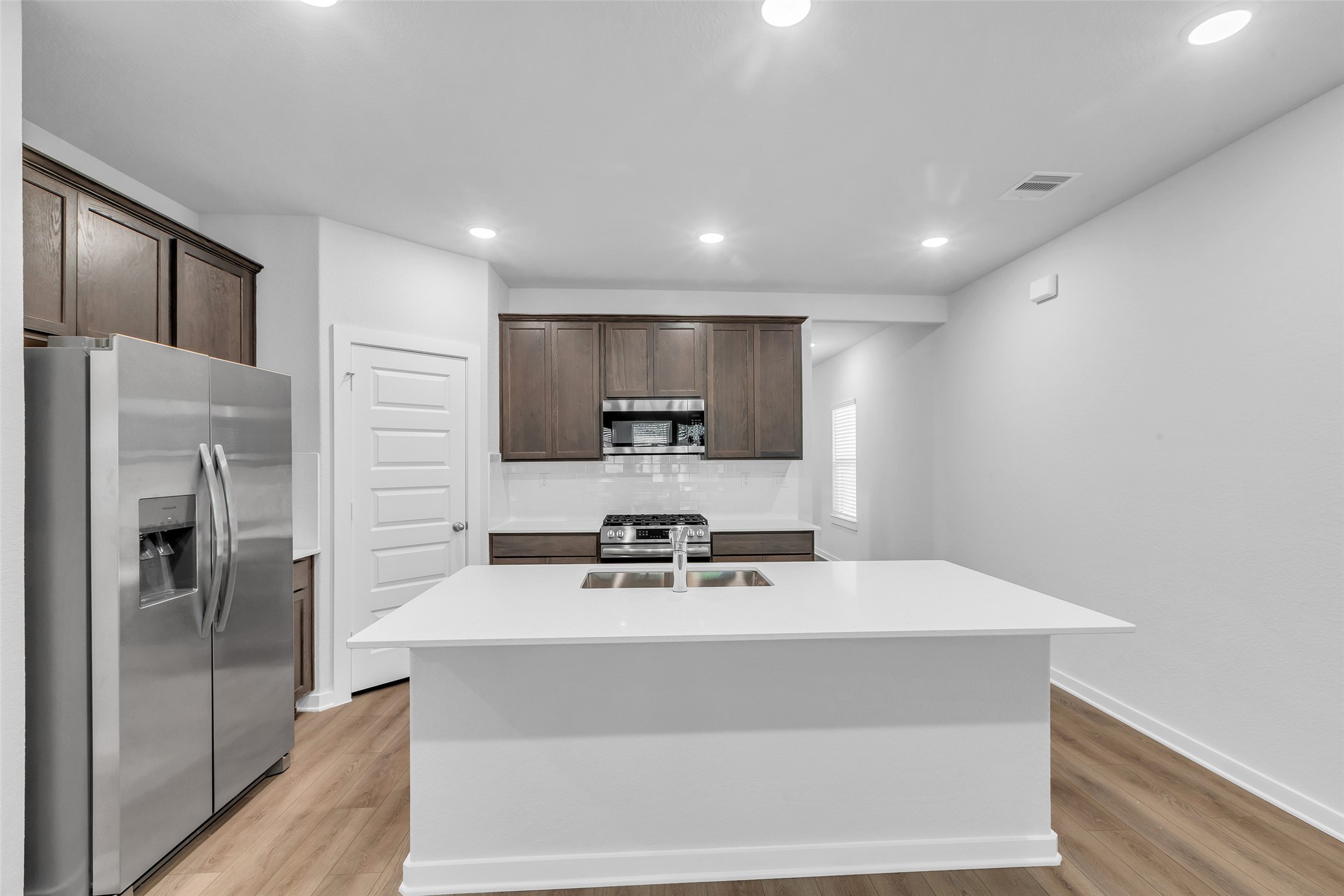 8550 Blueberry Ash Street Magnolia, TX 77354 - Photo 5 of 40 a kitchen with stainless steel appliances a refrigerator sink and microwave