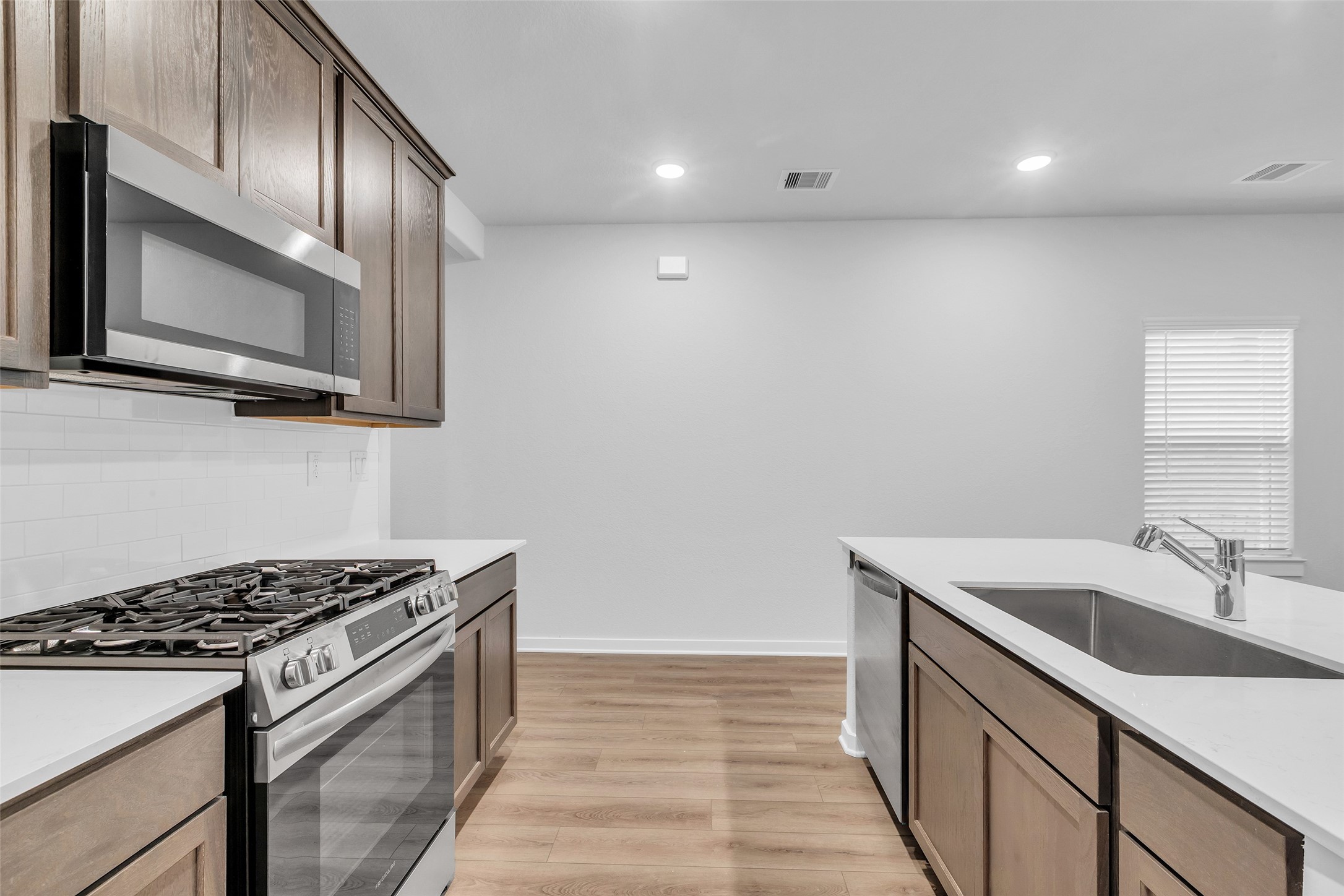 8550 Blueberry Ash Street Magnolia, TX 77354 - Photo 10 of 40 a kitchen that has a sink wooden cabinets and stainless steel appliances