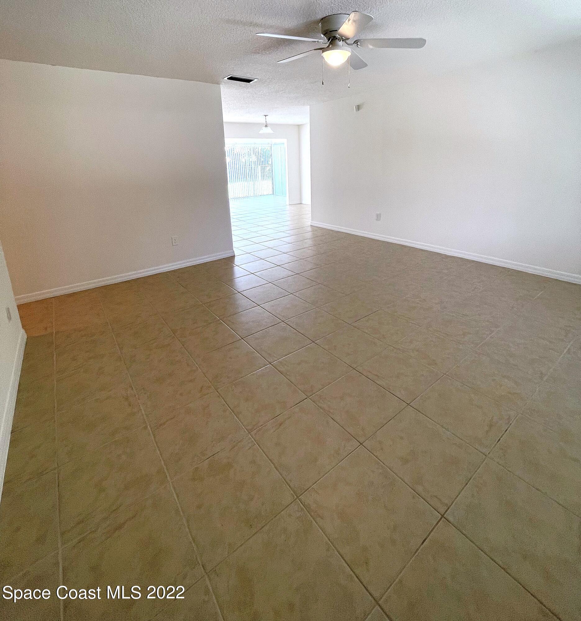 1440 Creel Road Northeast Palm Bay, FL 32905 - Photo 8 of 27 a view of a room with an empty space and a ceiling fan