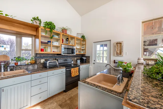 a kitchen with stainless steel appliances granite countertop a sink dishwasher stove and cabinets