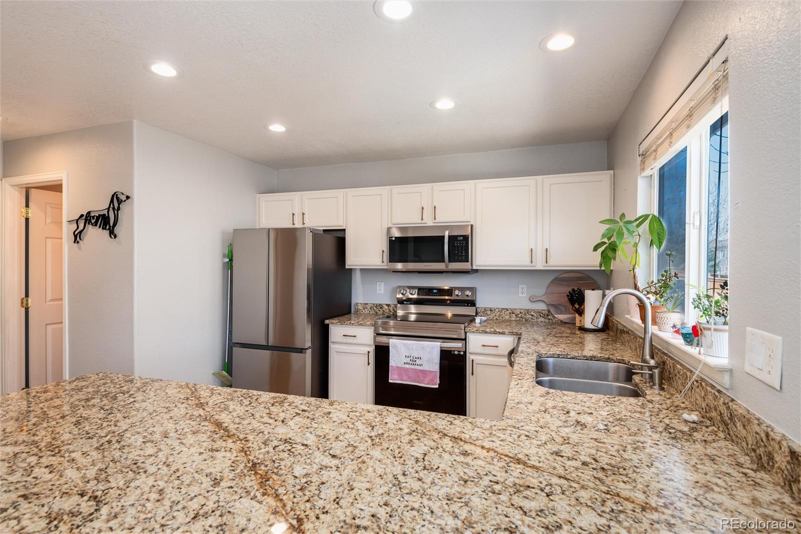 9867 Aftonwood Street Highlands Ranch, CO 80126 - Photo 12 of 41 a kitchen with stainless steel appliances granite countertop a refrigerator stove microwave and sink