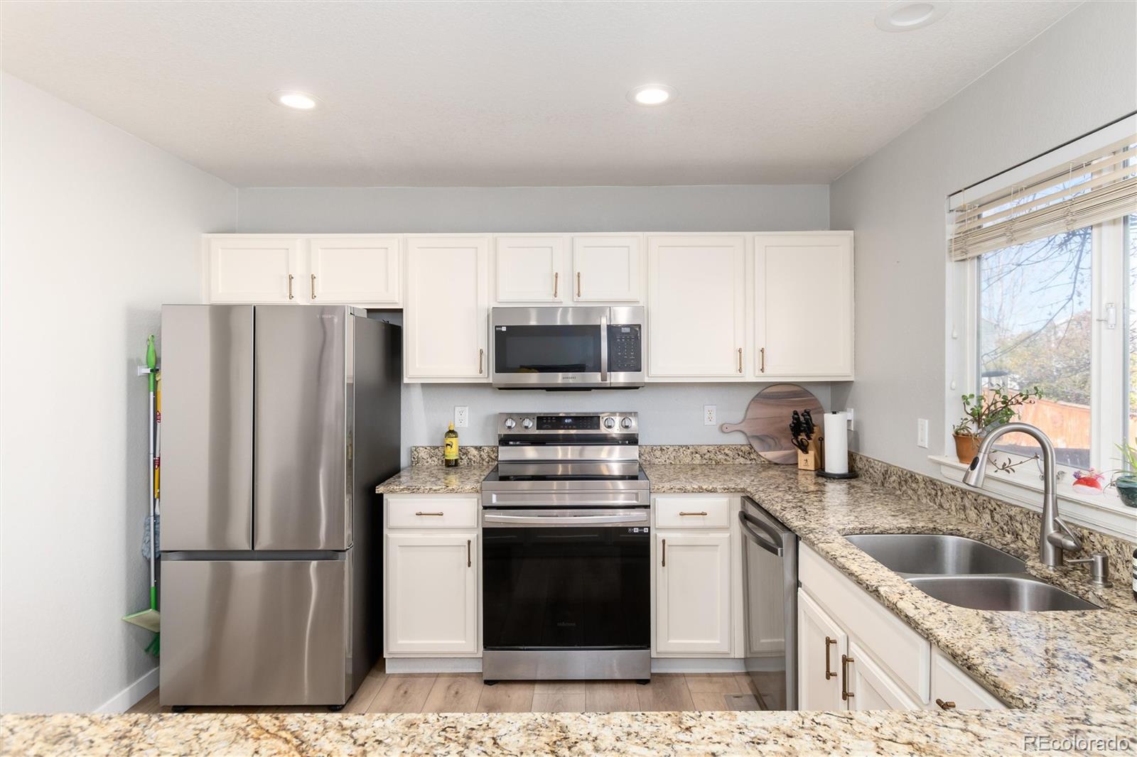 9867 Aftonwood Street Highlands Ranch, CO 80126 - Photo 13 of 41 a kitchen with granite countertop a refrigerator stove and sink