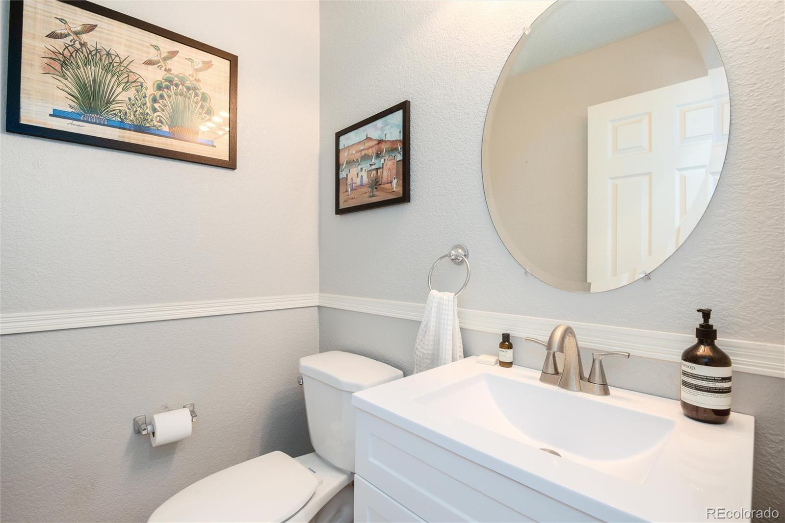 9867 Aftonwood Street Highlands Ranch, CO 80126 - Photo 15 of 41 a bathroom with a toilet a sink and a mirror