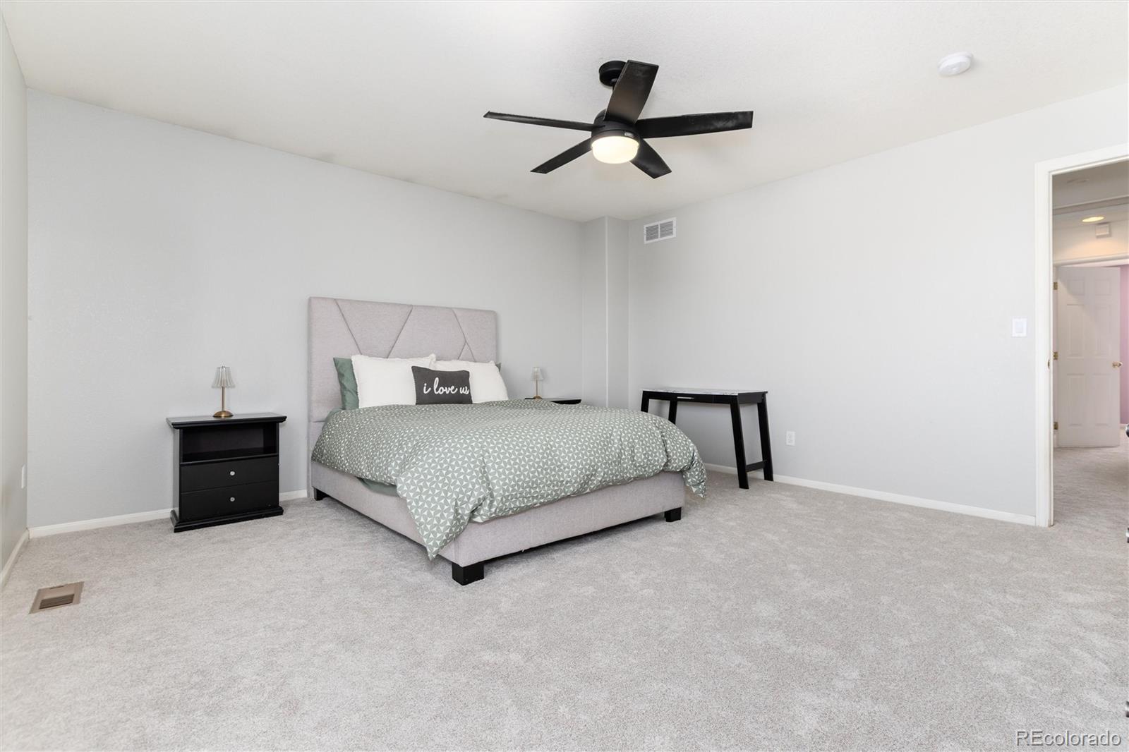 9867 Aftonwood Street Highlands Ranch, CO 80126 - Photo 17 of 41 a bedroom with a bed and a ceiling fan