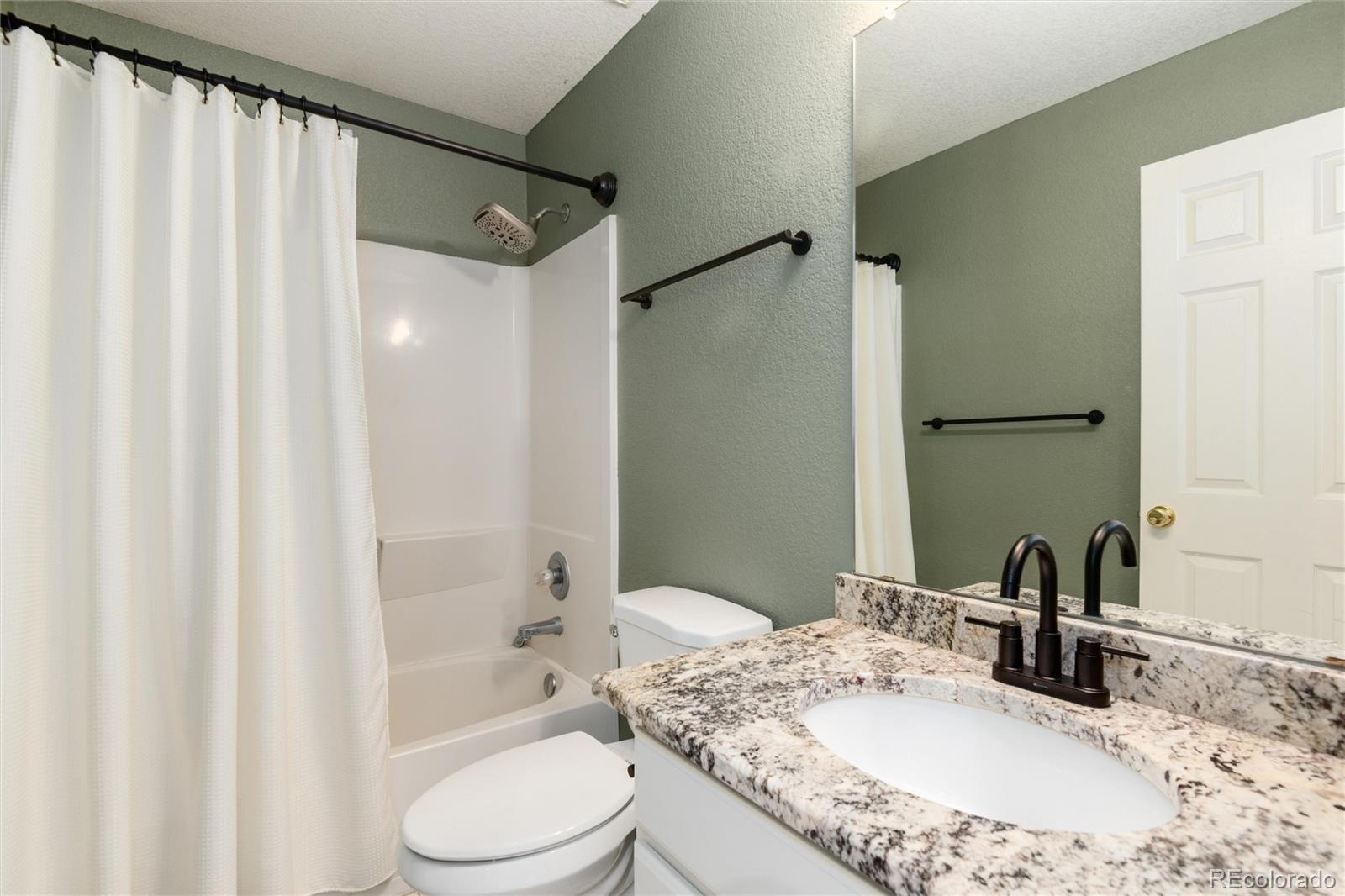 9867 Aftonwood Street Highlands Ranch, CO 80126 - Photo 22 of 41 a bathroom with a granite countertop sink toilet and shower