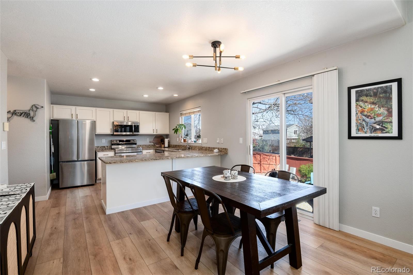 9867 Aftonwood Street Highlands Ranch, CO 80126 - Photo 10 of 41 a kitchen with a dining table chairs and refrigerator