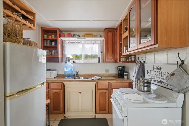 a view of a kitchen with fridge and washer dryer