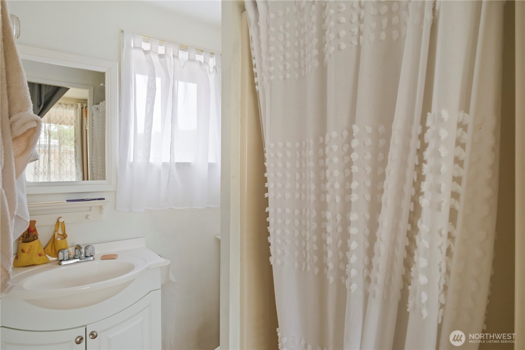 4 Memory Lane Copalis Beach, WA 98535 - Photo 16 of 29 a bathroom with a sink a mirror and a window