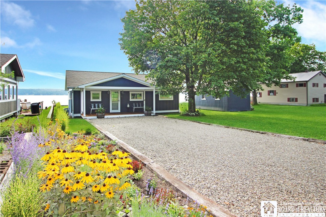 47 Bird And Tree Road Mayville, NY 14757 - Photo 1 of 1 Flowers and a stone drive highlight the entrance t