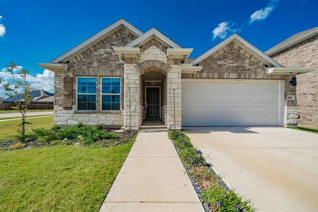 a front view of a house with a garden and plants