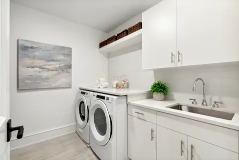 a utility room with sink dryer and washer