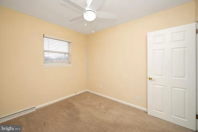 an empty room with a window and wooden floor