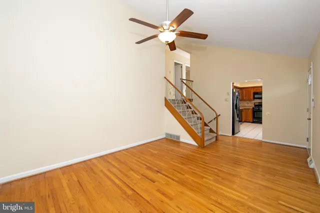 wooden floor in an empty room with a ceiling fan