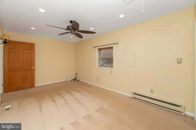 an empty room with a window and a fan