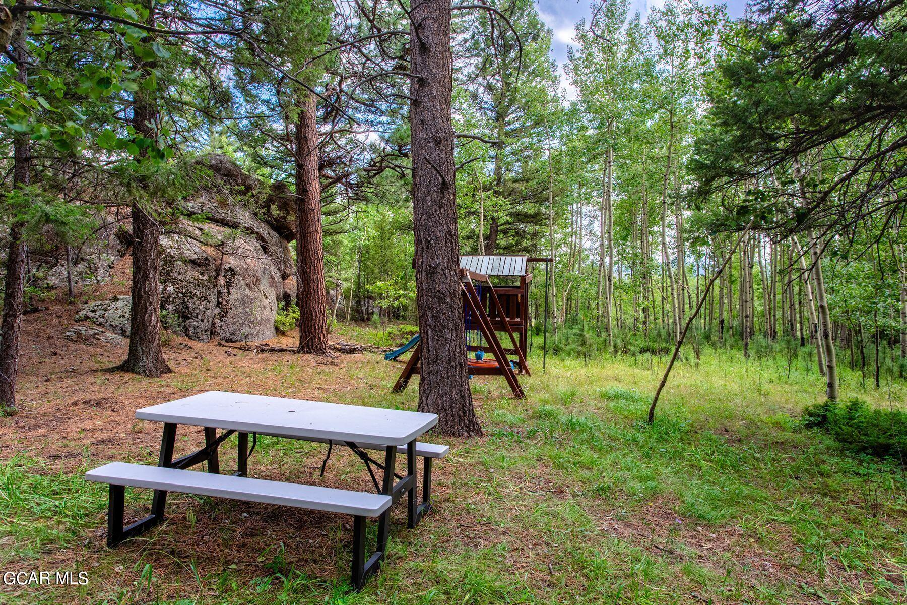 30539 Rand Road Conifer, CO 80433 - Photo 12 of 36 a backyard of a house with table and chairs