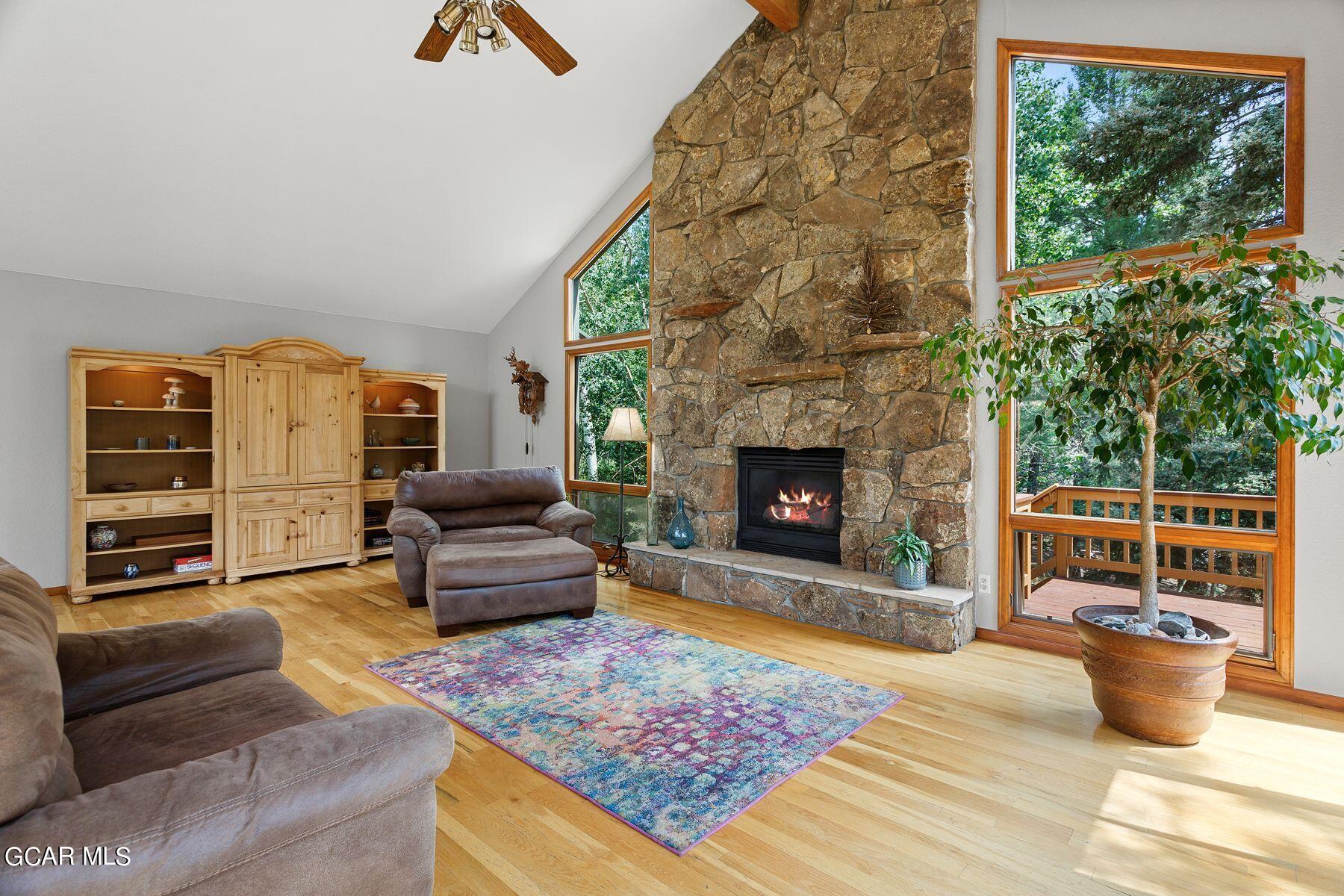 30539 Rand Road Conifer, CO 80433 - Photo 14 of 36 a living room with furniture and a fireplace