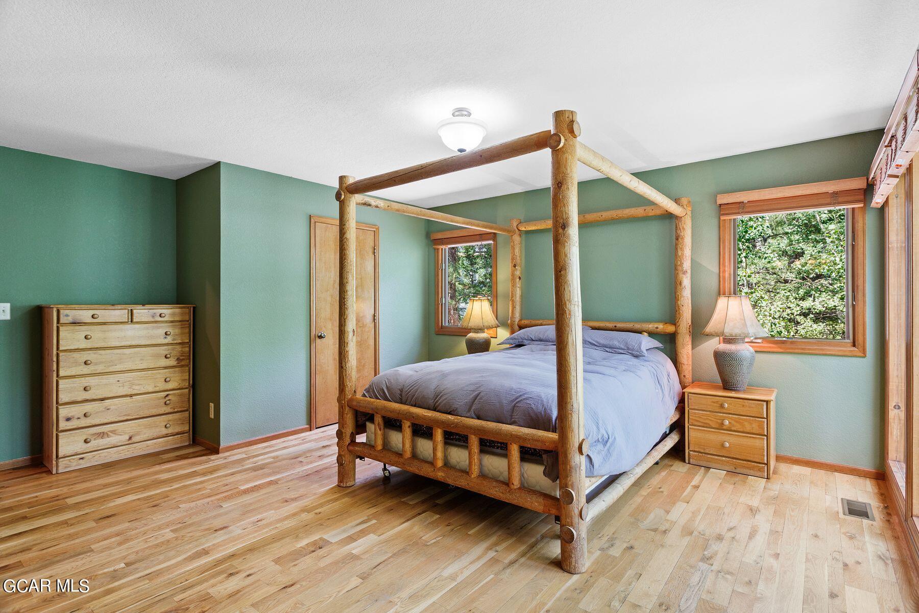 30539 Rand Road Conifer, CO 80433 - Photo 16 of 36 a bedroom with a bed lamp and a large window