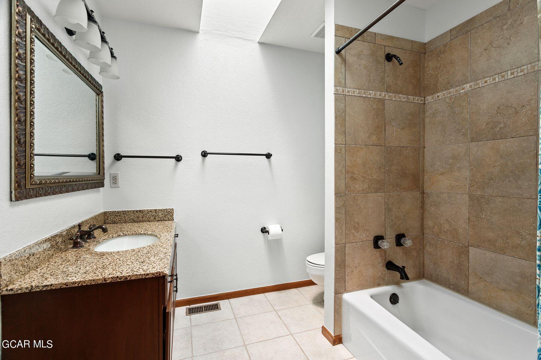 30539 Rand Road Conifer, CO 80433 - Photo 21 of 36 a bathroom with a granite countertop sink a mirror and a bathtub