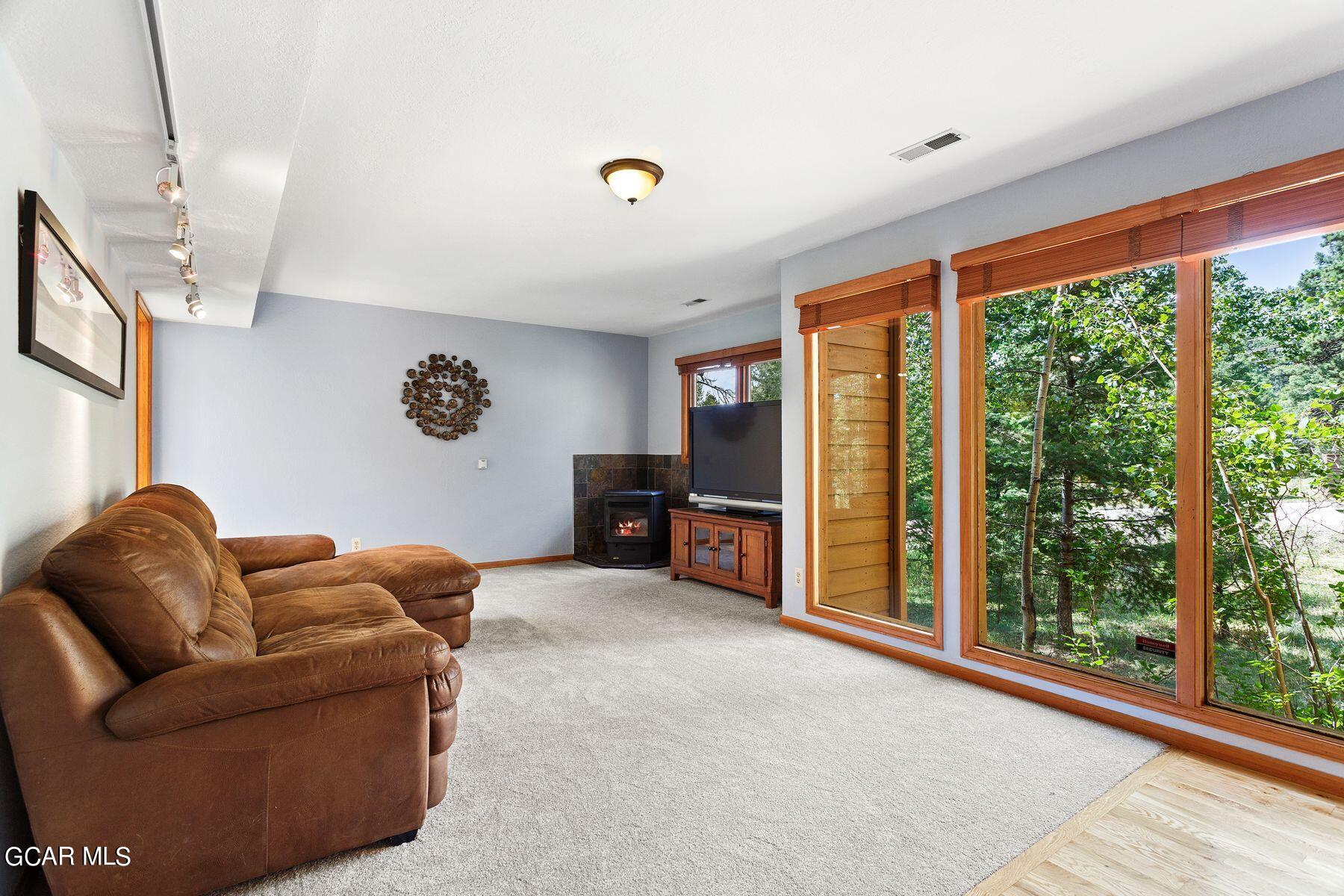 30539 Rand Road Conifer, CO 80433 - Photo 22 of 36 a living room with furniture and a flat screen tv