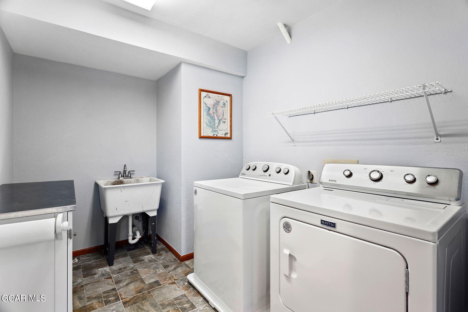 30539 Rand Road Conifer, CO 80433 - Photo 25 of 36 a view of a storage & utility room with dryer and washer
