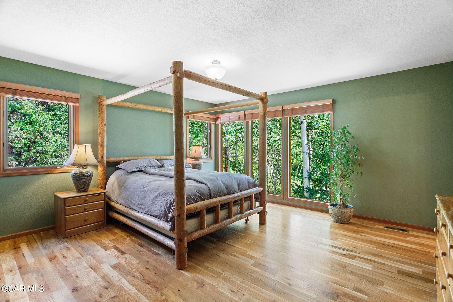 30539 Rand Road Conifer, CO 80433 - Photo 4 of 36 a bed sitting in a spacious bedroom next to a window