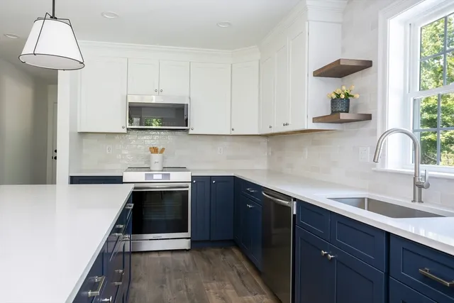 a kitchen with kitchen island a stove a sink a center island and a window