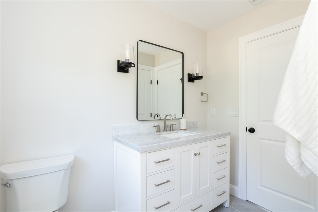 65 Great Neck Road Wareham, MA 02571 - Photo 21 of 41 a bathroom with a granite countertop sink toilet and mirror