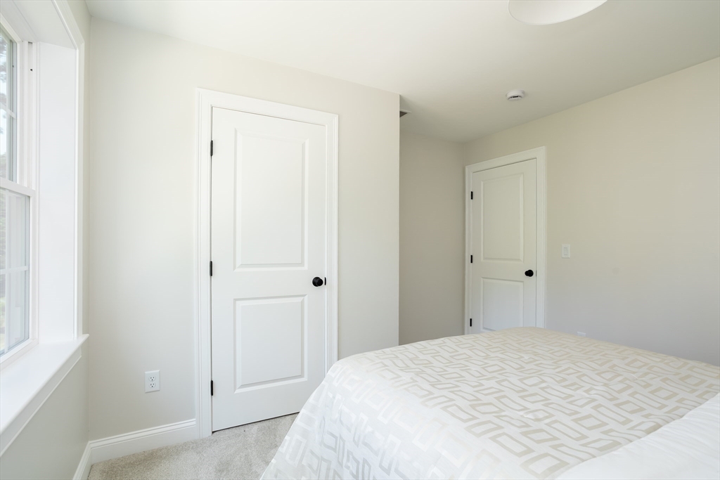 65 Great Neck Road Wareham, MA 02571 - Photo 30 of 41 a bedroom with a bed and a mirror