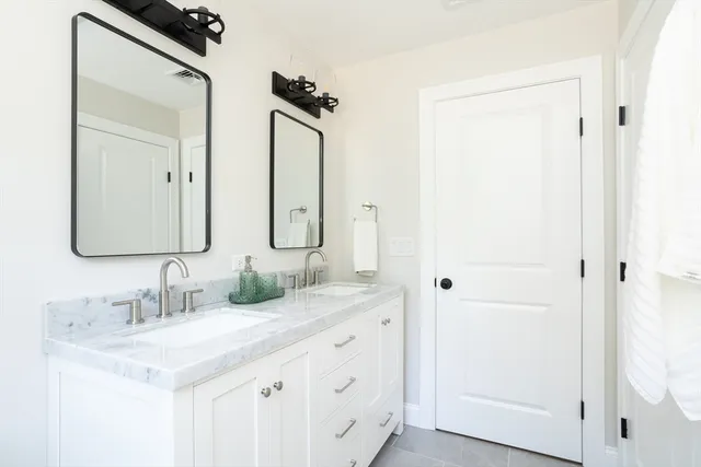 a bathroom with a double vanity sink and mirror